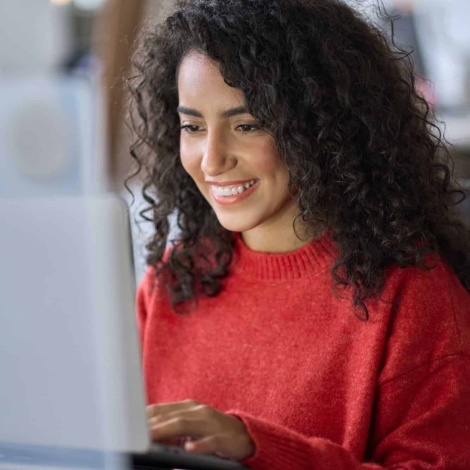 young-happy-latin-woman-student-elearning-using-laptop-vertical-shot.jpg